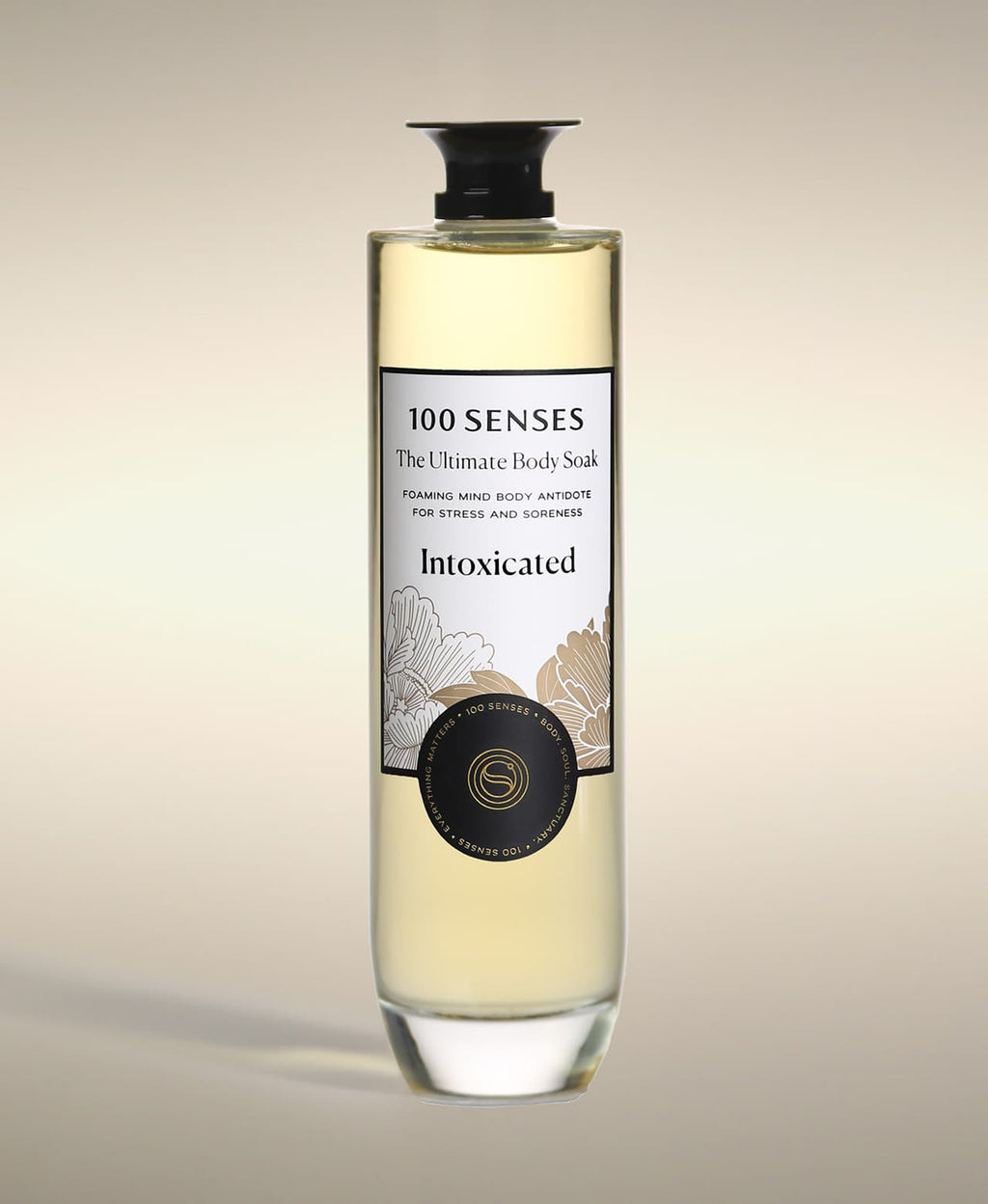 Intoxicated Ultimate Body Soak in a thick-bottomed glass bottle with botanical label artwork.