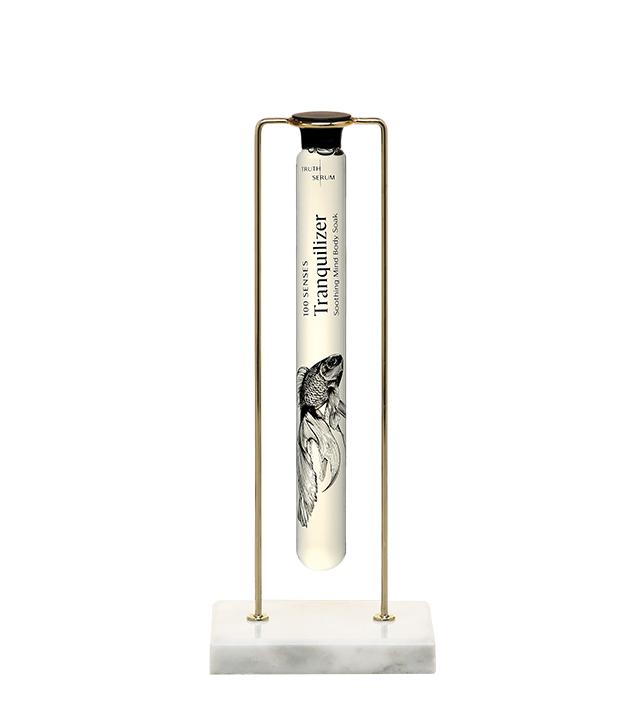 The Cylinder and Stand Duo: Tranquilizer Foaming Cylinder Soak floating in the gold and white marble single stand