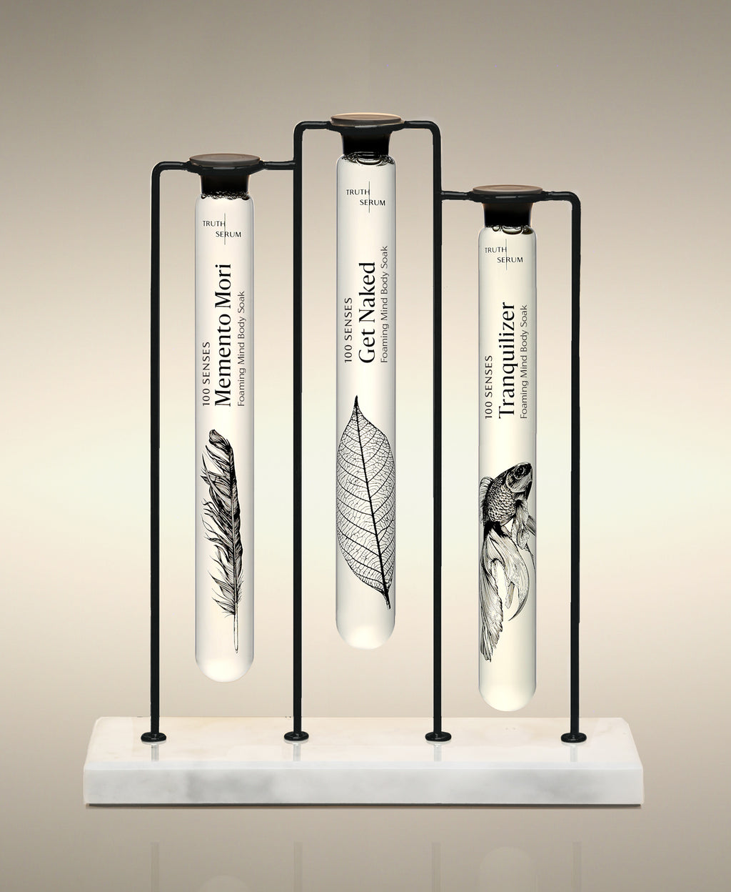 Memento Mori, Get Naked and Tranquilizer glass Foaming Cylinder Soaks displayed in the Trio Cylinder Soak Stand in black-and-marble.