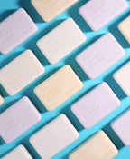 Pastel Ultimate Body Bars arranged diagonally across a light blue background.