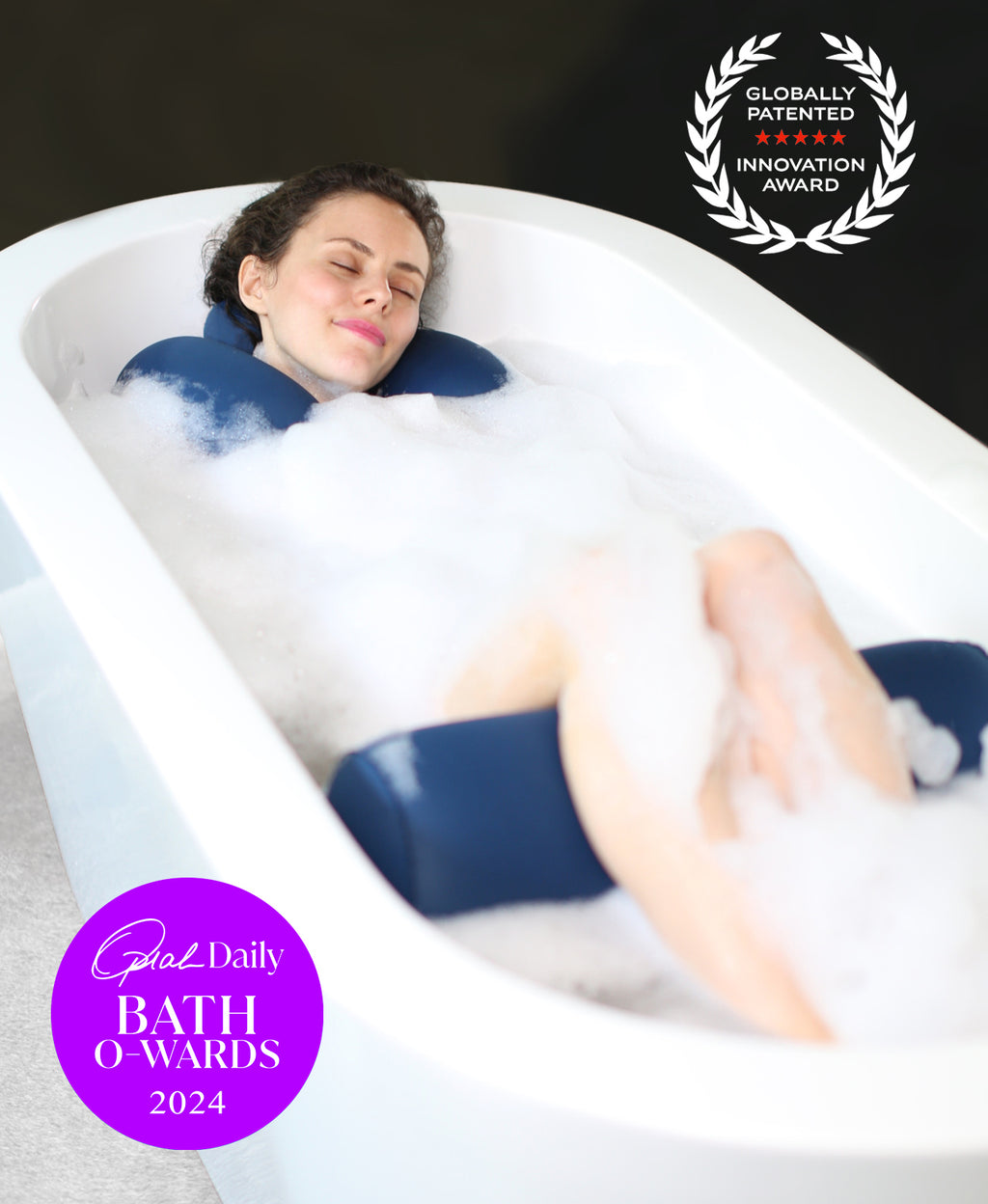 Woman reclining in a foaming bath soak with the Full Body Float Duo and Bath O-Wards 2024 and innovation award badges.
