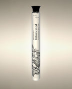 Intoxicated Foaming Bath Soak glass cylinder with a floral illustration, standing against a warm neutral background.