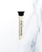 Memento Mori Singular Soak glass vial on white marble.