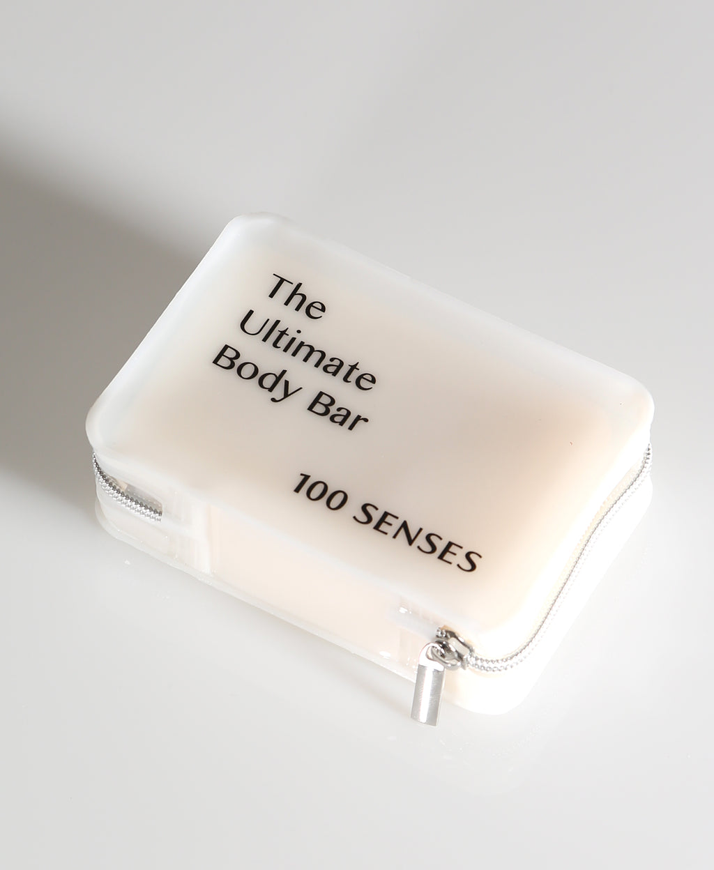 A frosted TPU Ultimate Body Bar zippered  travel case with black text reading 'The Ultimate Body Bar' and '100 SENSES' on a light gray background.