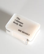 A frosted TPU Ultimate Body Bar zippered  travel case with black text reading 'The Ultimate Body Bar' and '100 SENSES' on a light gray background.