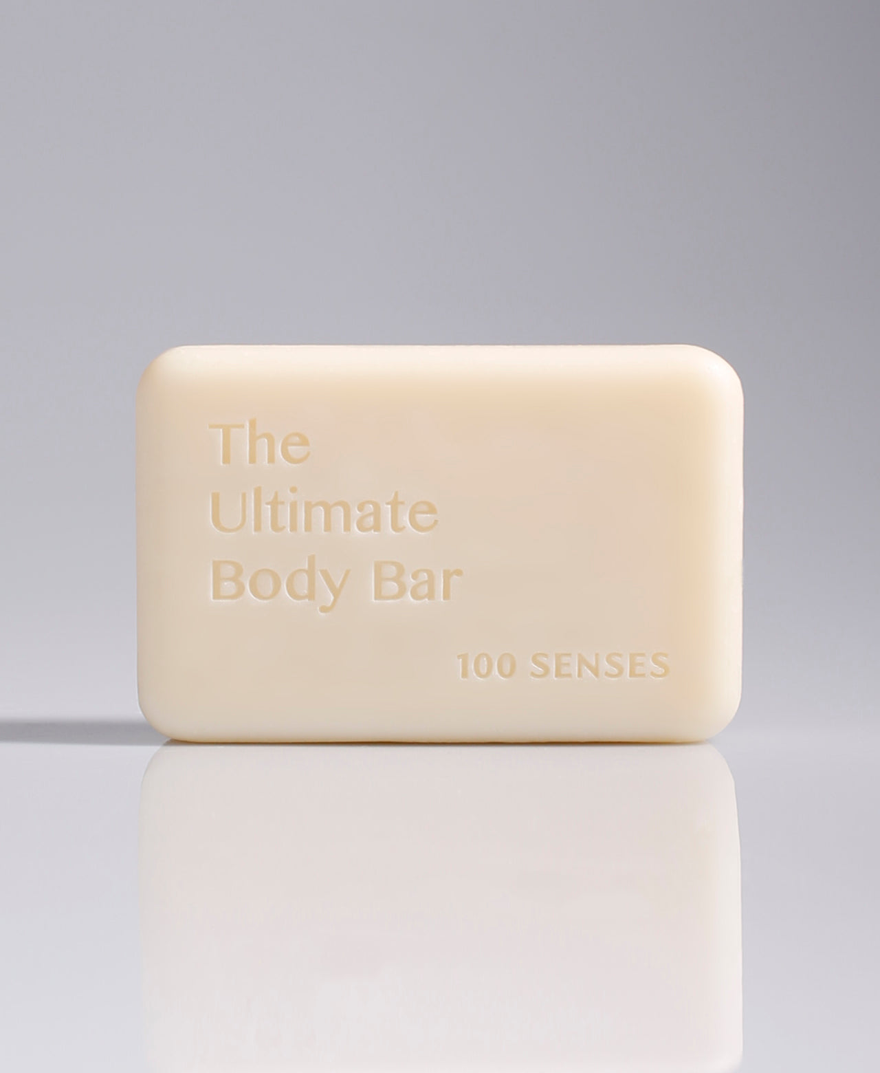 Cream-colored Ultimate Body Bar standing upright against a pale gradient gray background.