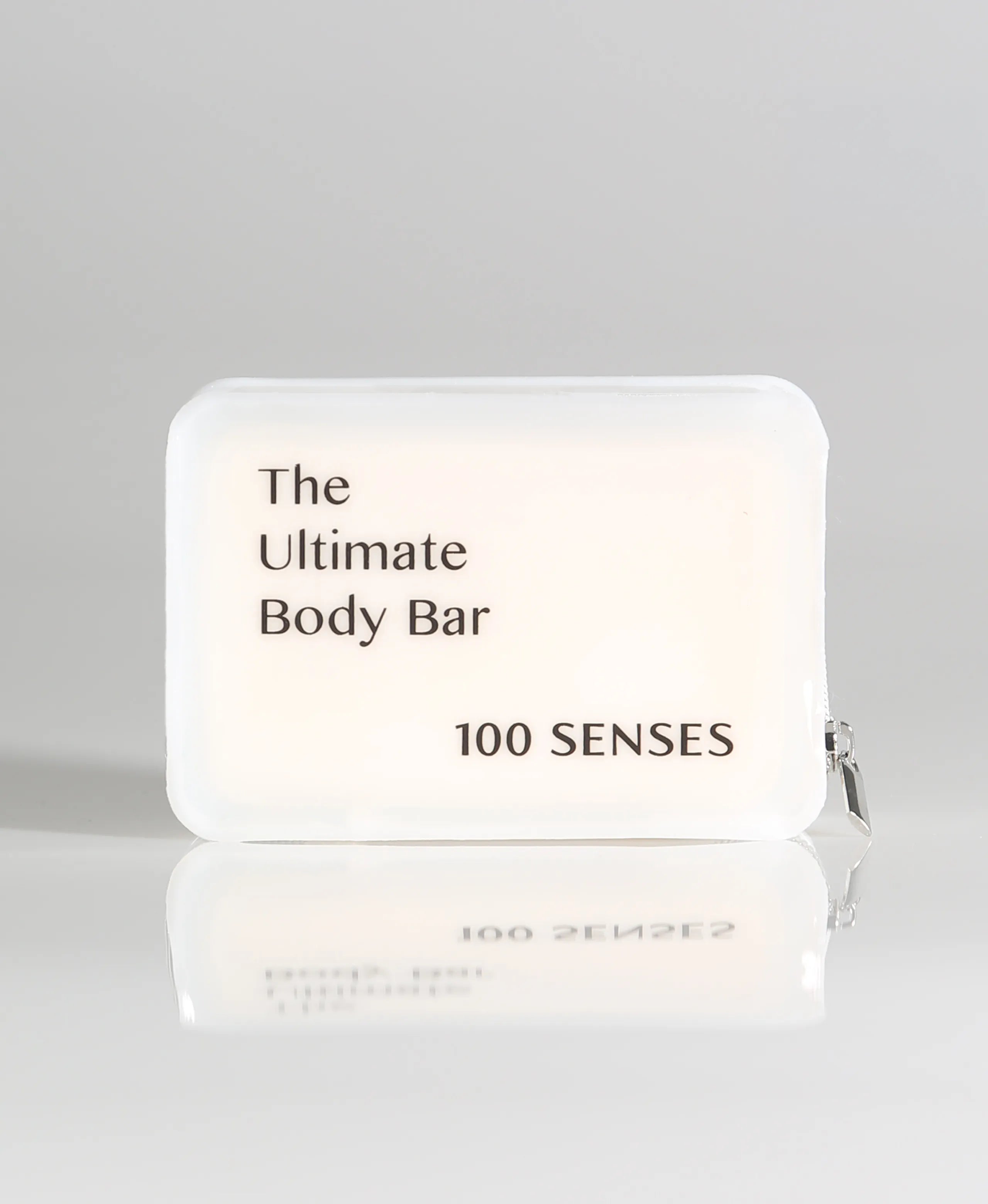 A rectangular TPU body bar travel case labeled 'The Ultimate Body Bar' and '100 SENSES' on a light gray background with a soft reflection below.