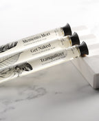 Memento Mori, Get Naked and Tranquilizer glass Foaming Cylinder Soaks resting on white marble.