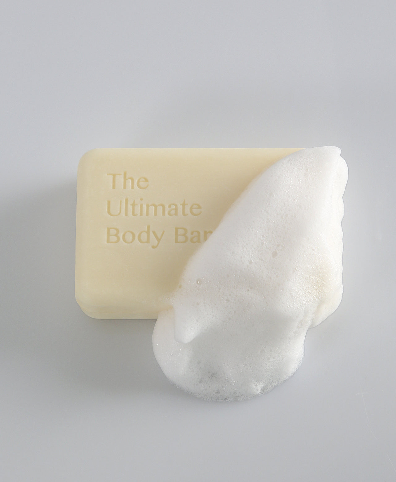 Ultimate Body Bar partly covered in a mound of soft white lather.
