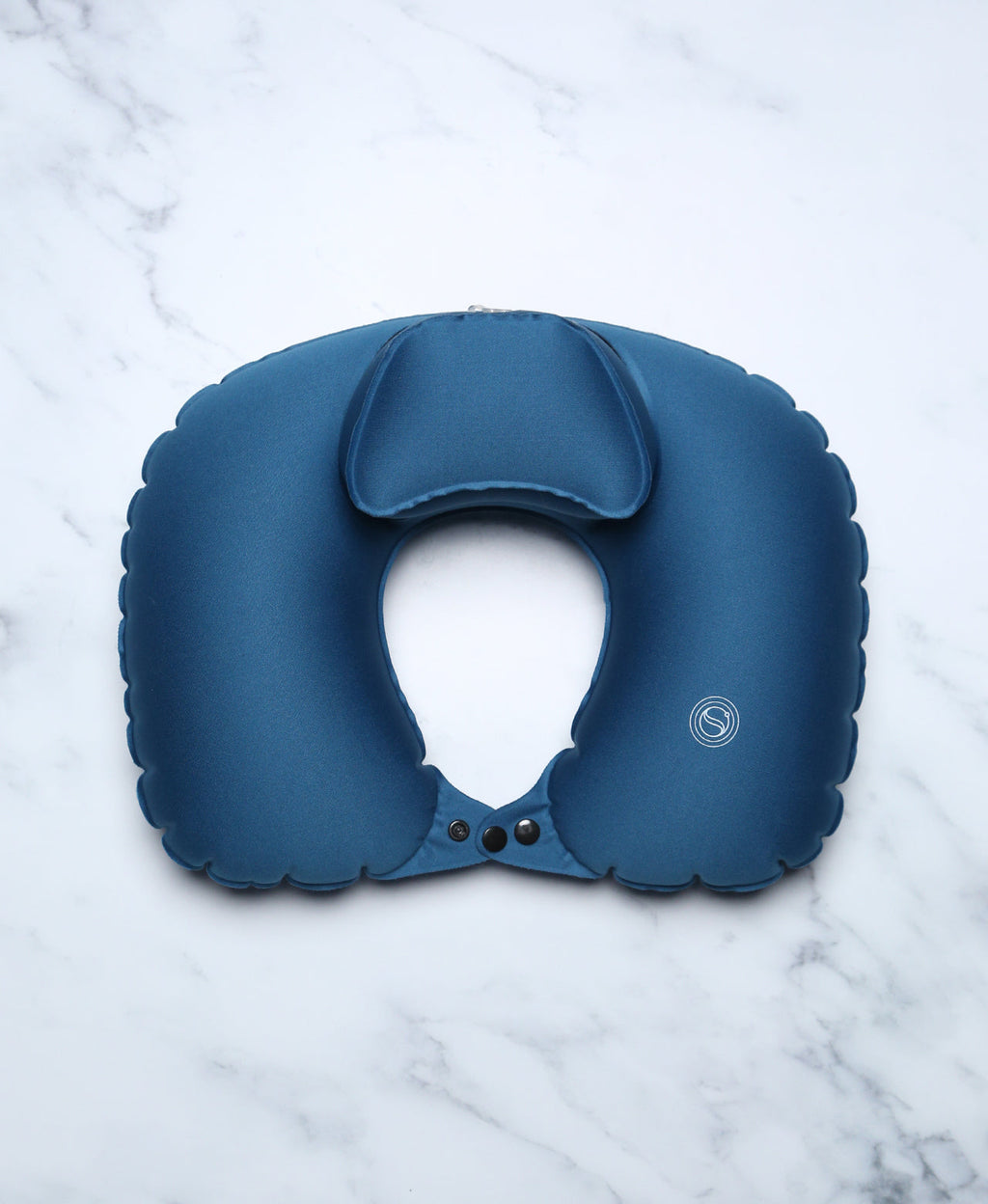 Blue U-shaped Head Floater bath pillow snapped closed on white marble.