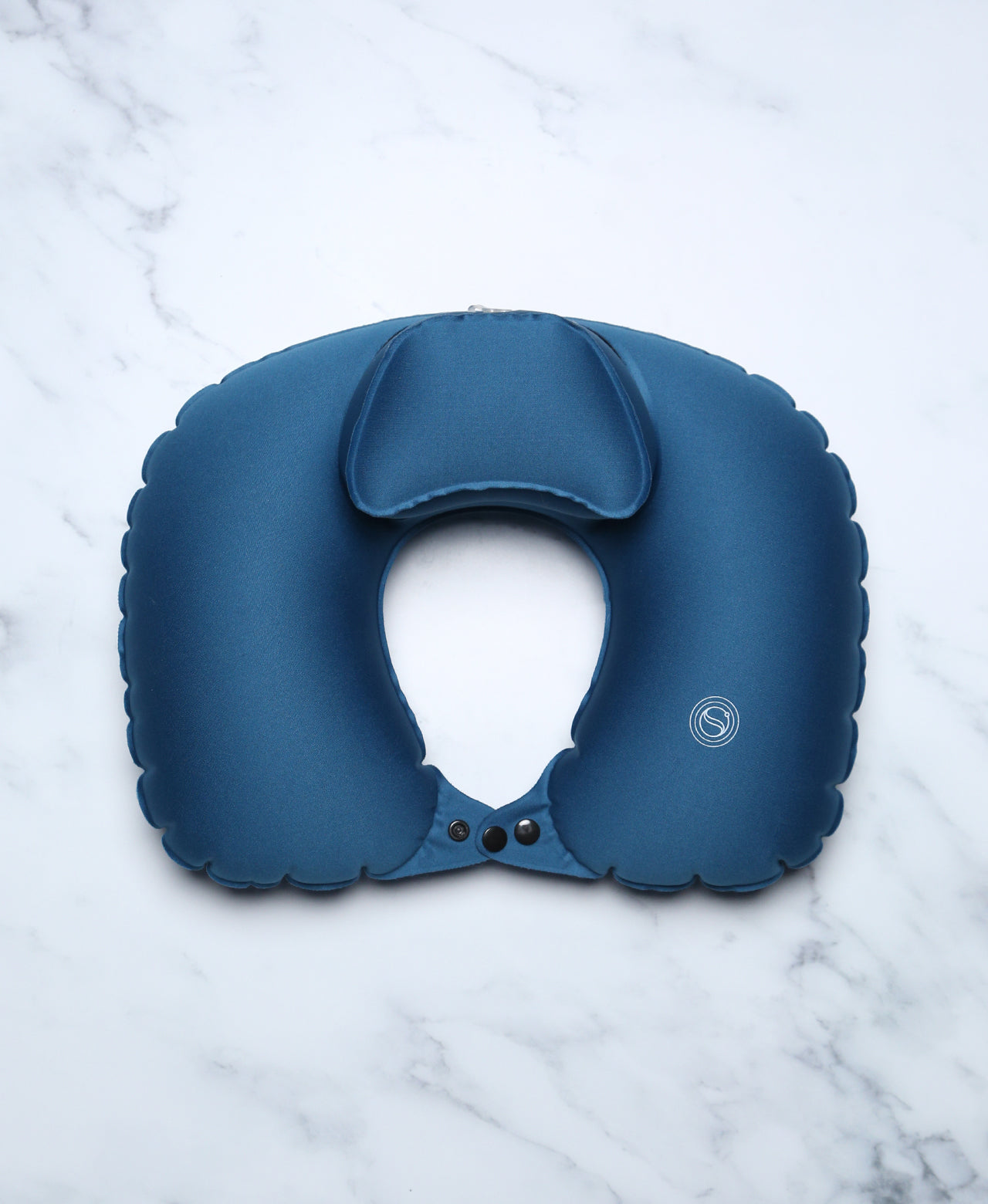 Blue U-shaped Head Floater bath pillow snapped closed on white marble.