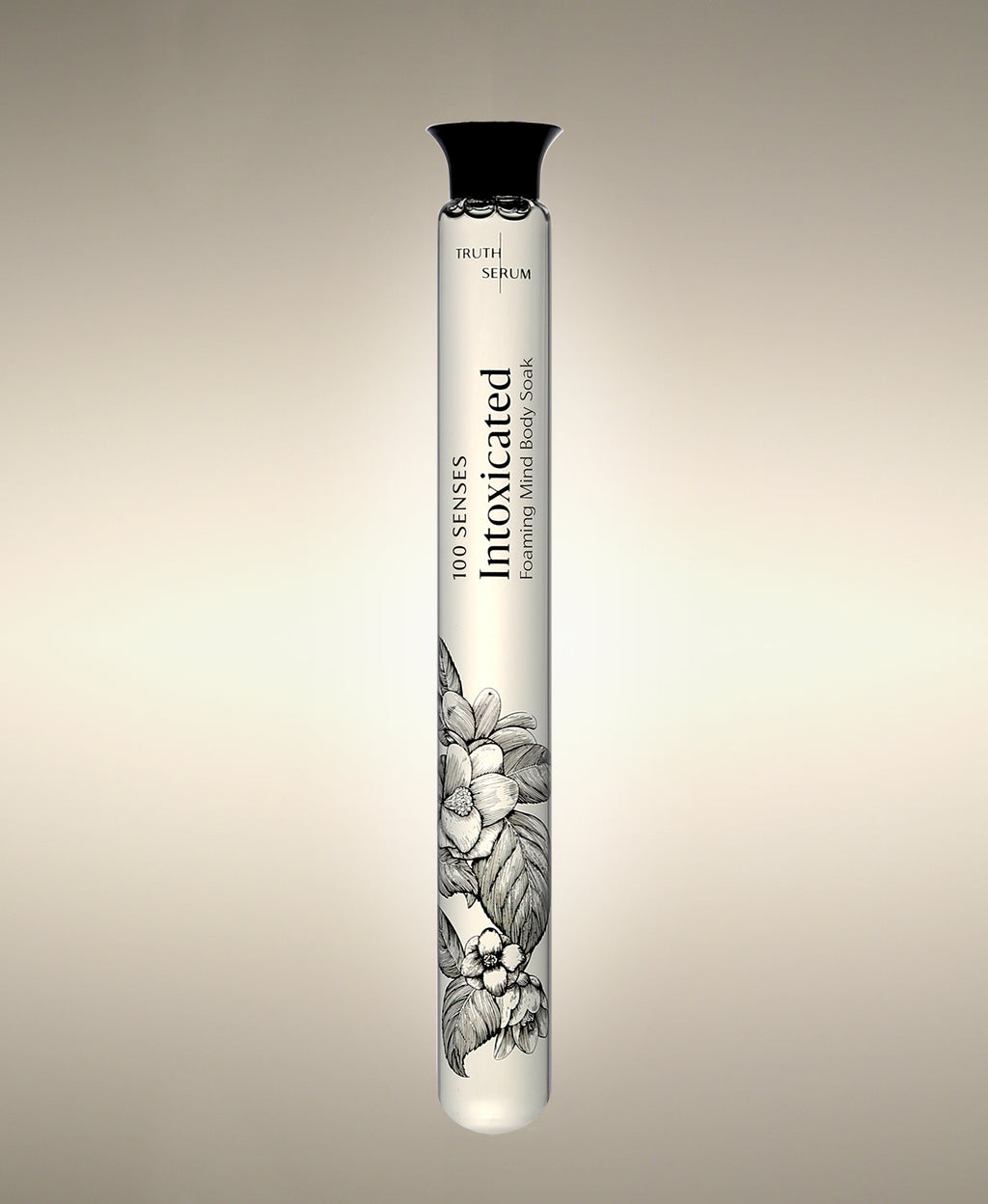 Intoxicated Foaming Bath Soak glass cylinder with a floral illustration, standing against a warm neutral background.