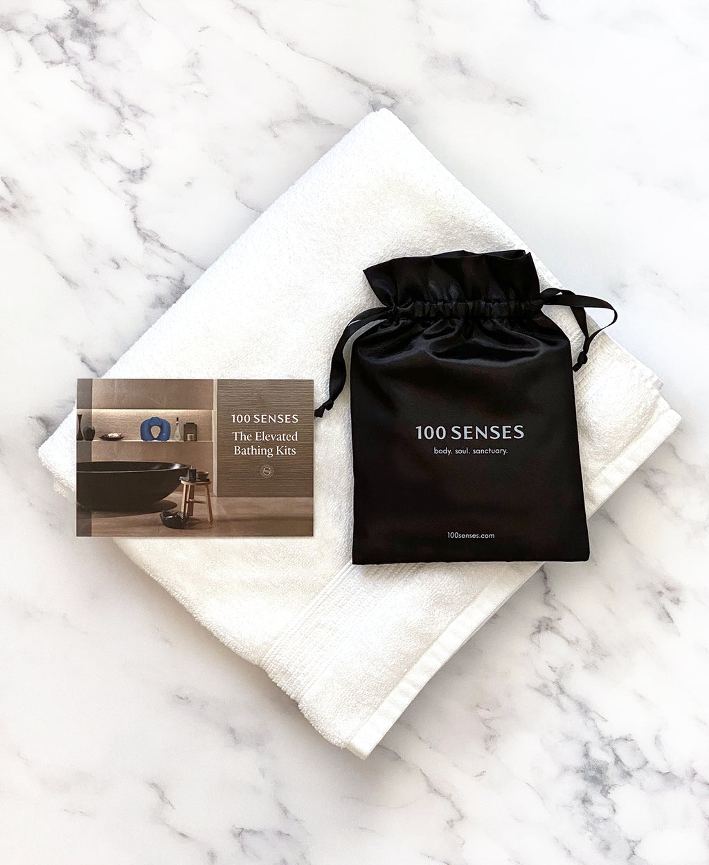Head Floater card and black satin storage bag arranged on a folded white towel.