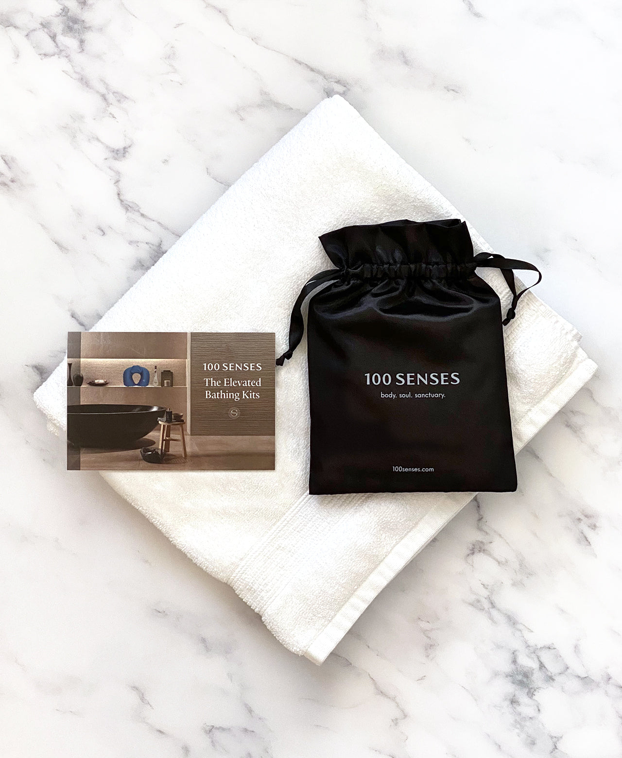 Head Floater card and black satin storage bag arranged on a folded white towel.