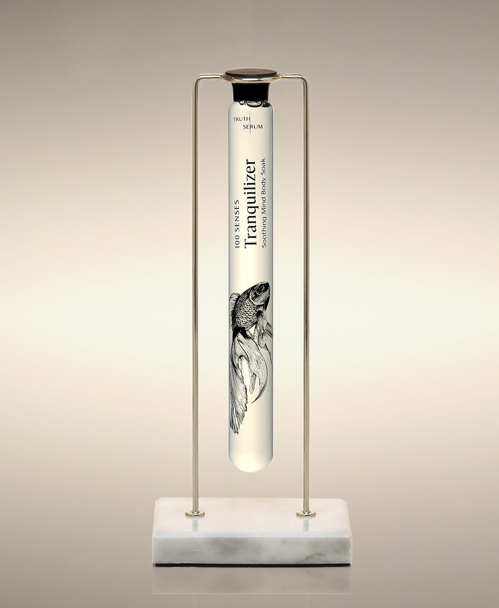Tranquilizer glass Foaming Cylinder Soak displayed in a gold metal stand on a marble base.