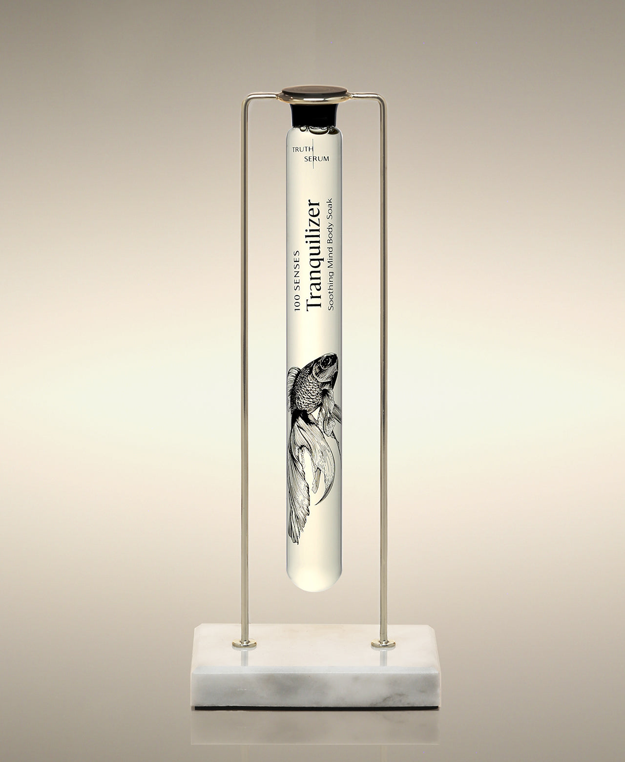 Tranquilizer glass Foaming Cylinder Soak displayed in a gold metal stand on a marble base.