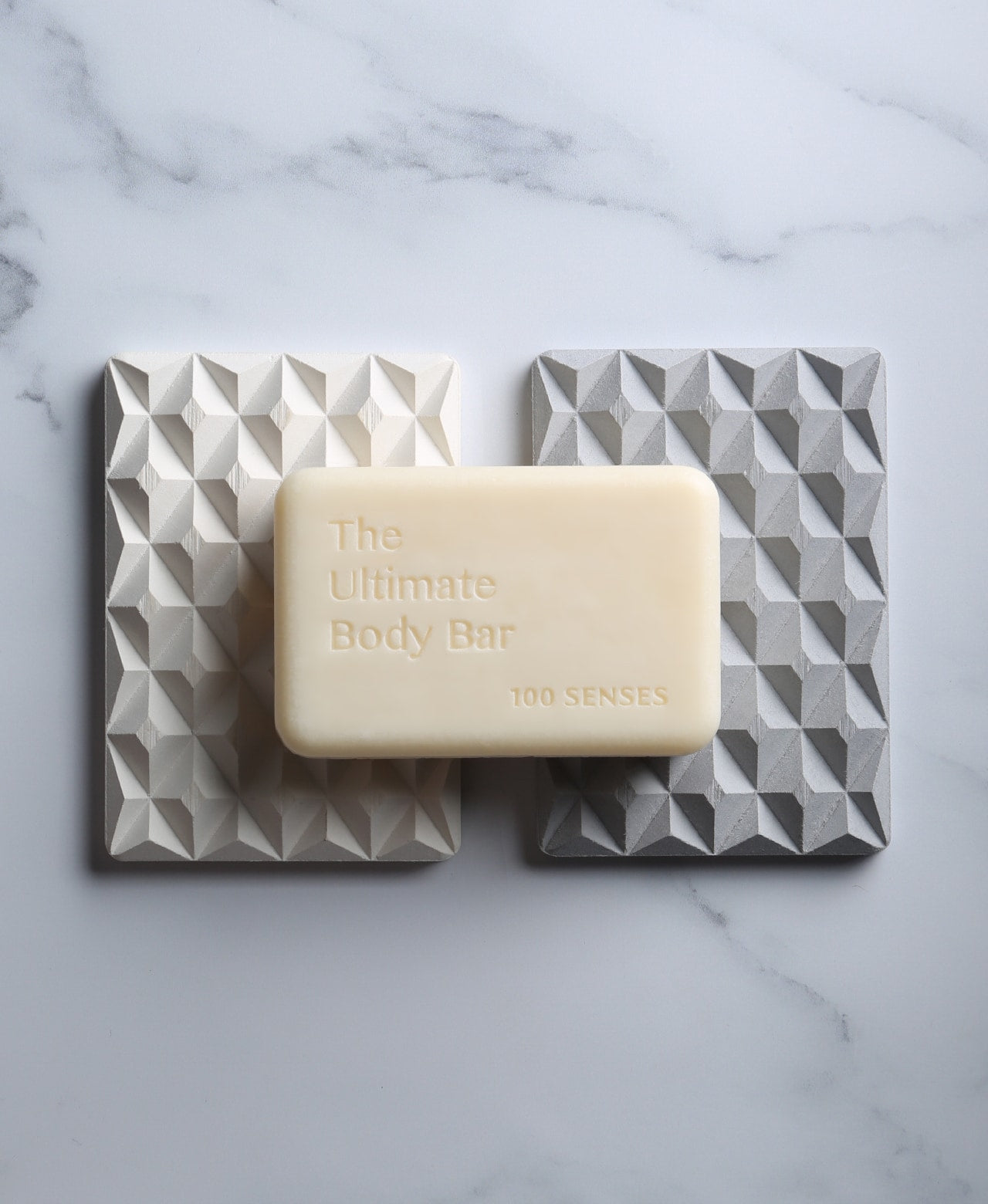 The Ultimate Body Bar resting across natural white and stone gray 3D Pyramid Bar Rests.