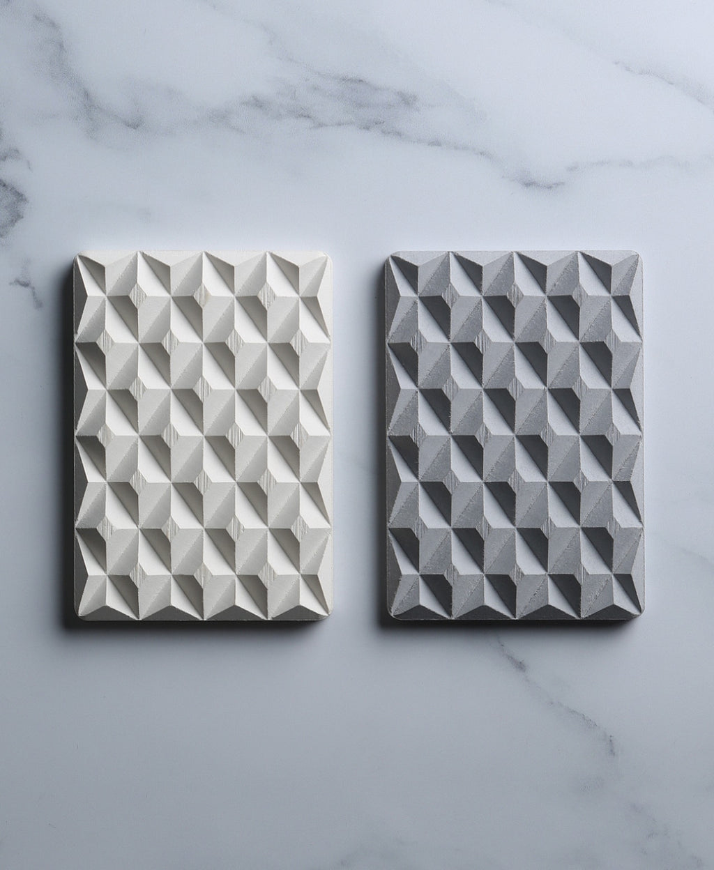 Natural white and stone gray 3D Pyramid Body Bar Rests with faceted pyramid patterns on marble.