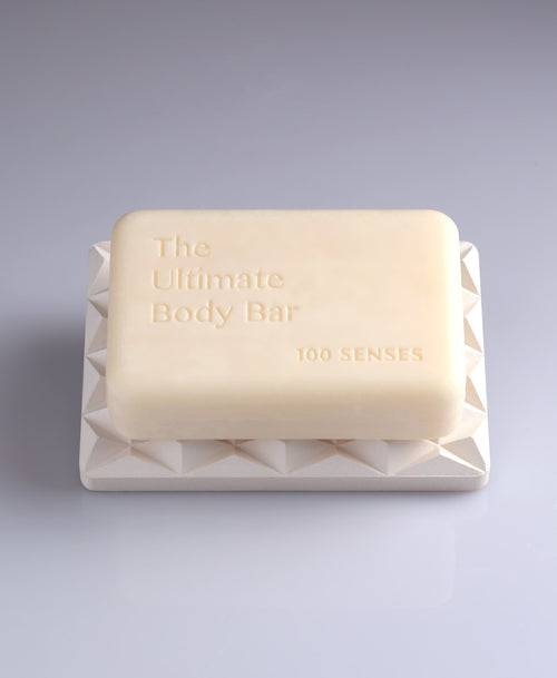 Ultimate Body Bar resting on a white geometric 3D Pyramid Body Bar Rest.